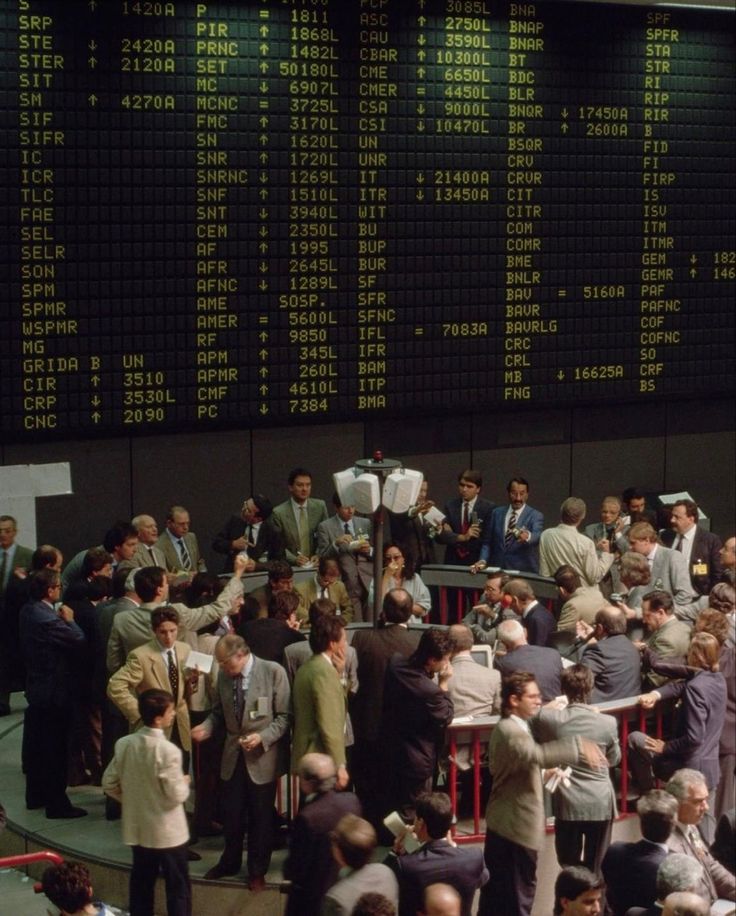 Busy trading floor beneath a market board